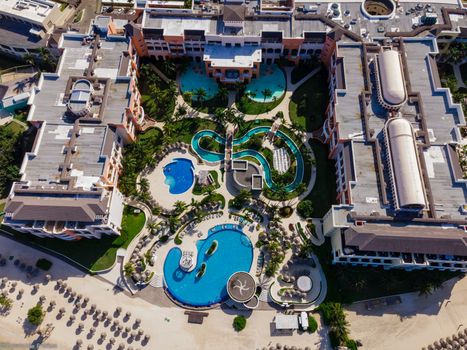 Stel geniet ontspannen bij zwembad tijdens last minute all inclusive vakantie in zonnig resort