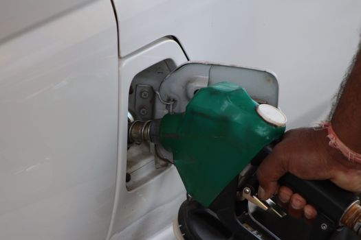 Tankstation in Groei met prijsbord voor brandstof en auto's langs een drukke invalsweg