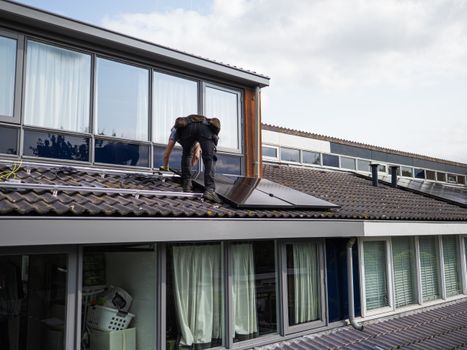 Huiseigenaar bekijkt zonnepanelen op het dak terwijl de gevolgen van saldering zonnepanelen 2027 worden uitgelegd